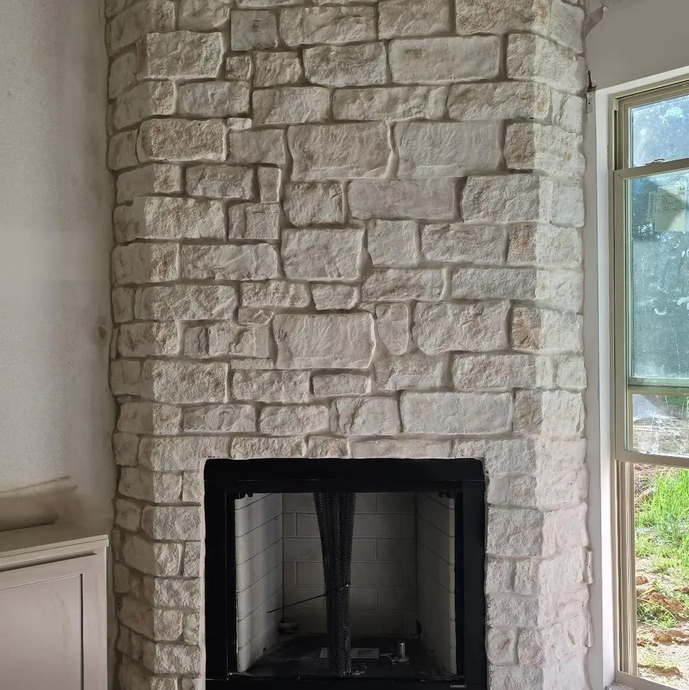 Light stone fireplace surround with a custom live-edge hearth.